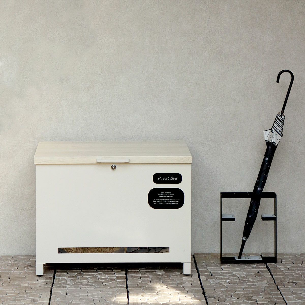 グレージュの宅配ボックスの設置イメージ。傘立てと並べて玄関先に置いた時のイメージ。