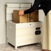 グレージュの宅配ボックスの設置イメージ。女性が宅配ボックスから段ボールの荷物を取り出している。