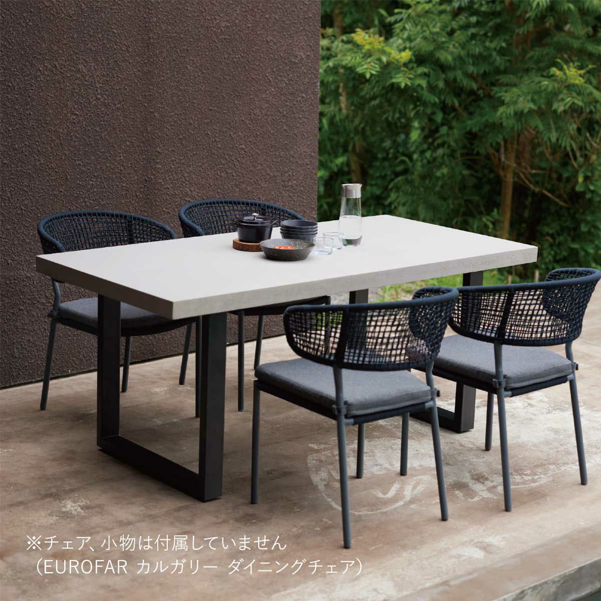 屋外のベージュの床のデッキに、白い天板のダイニングテーブルと4脚のチェアが置かれている画像です。※チェア、小物は付属していません（EUROFAR カルガリー ダイニングチェア）