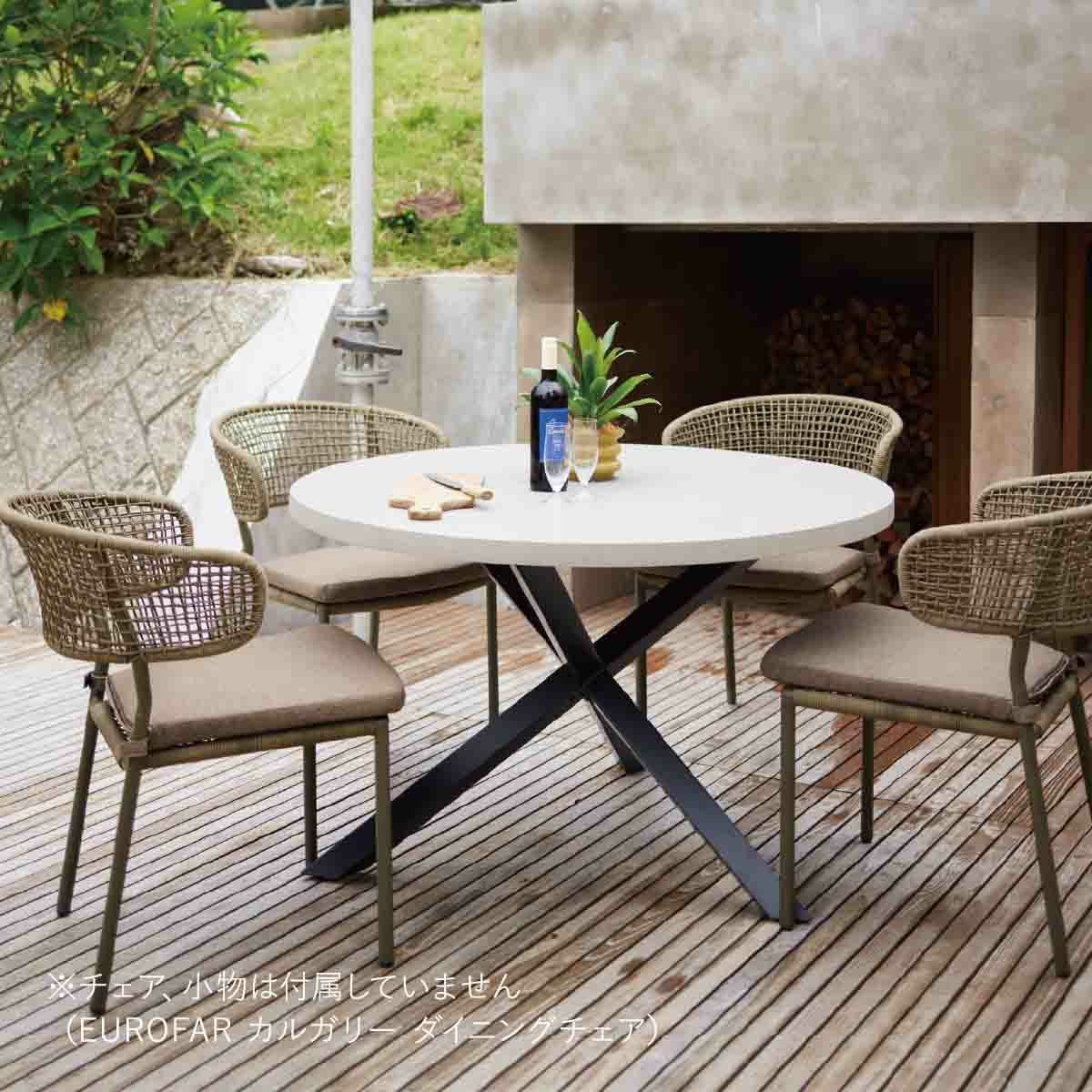 屋外のデッキに円形のテーブルとダイニングチェアが4脚置かれている画像です。チェア、小物は付属していません（EUROFAR カルガリー ダイニングチェア）