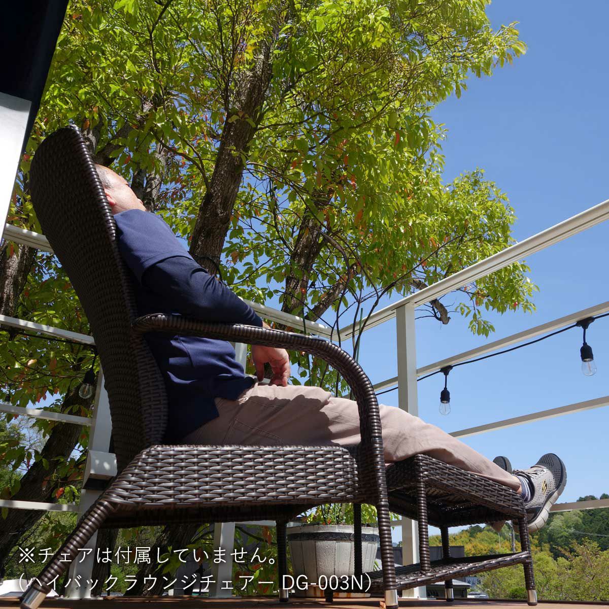 同素材のハイバックチェアと一緒に使用して、屋外デッキで男性がくつろいでいる画像。こちらの商品ページはオットマン単品の為、チェアは付属していません。