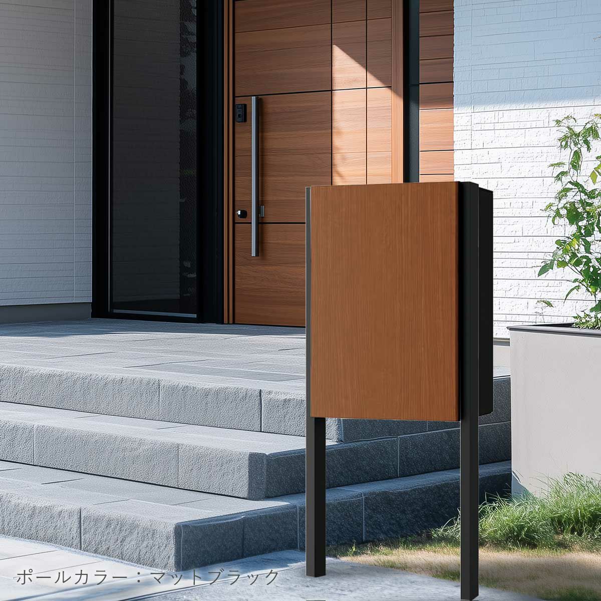 ナスタボックスプラスポストの設置イメージ。住宅の玄関ポーチ横に設置されている。宅配ボックスのカラーは木目調のMウォールナット、ポールのカラーはマットブラック。