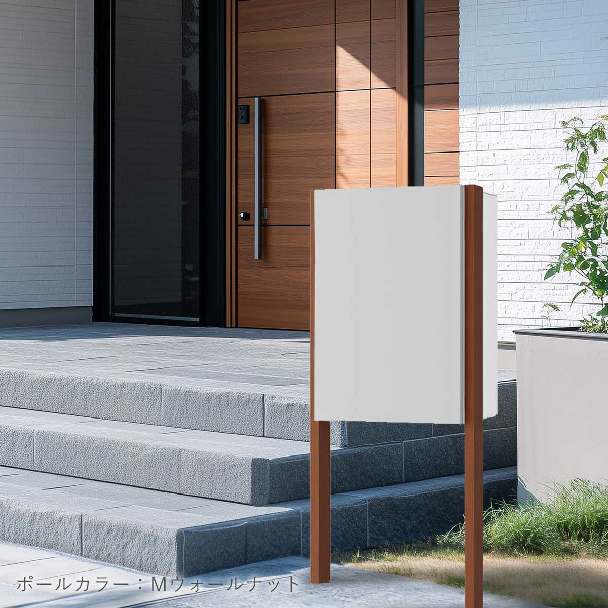 ナスタボックスプラスポストの設置イメージ。住宅の玄関ポーチ横に設置されている。宅配ボックスのカラーはライトグレー、ポールのカラーはMウォールナット。